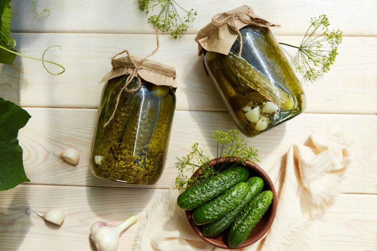 Stoppa jäsningen i pickles illustreras med tre burkar fulla med pickles